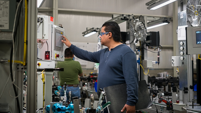 Industrial automation equipment engineer testing a machine and charting it 