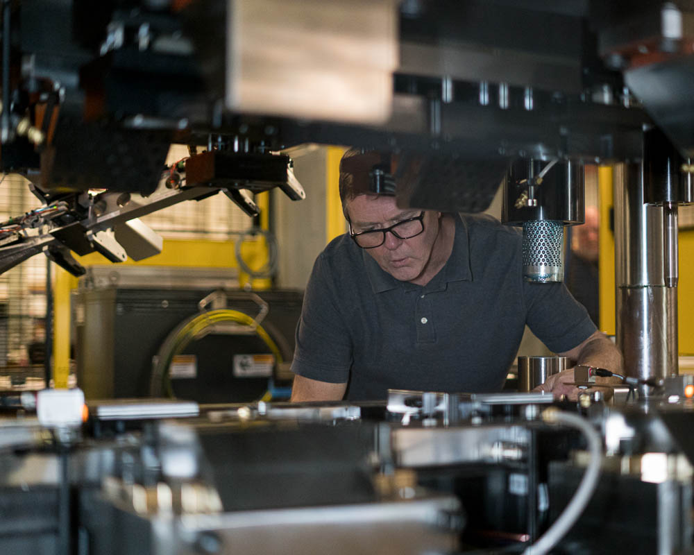 Ahaus employee making adjustments to automated assembly.