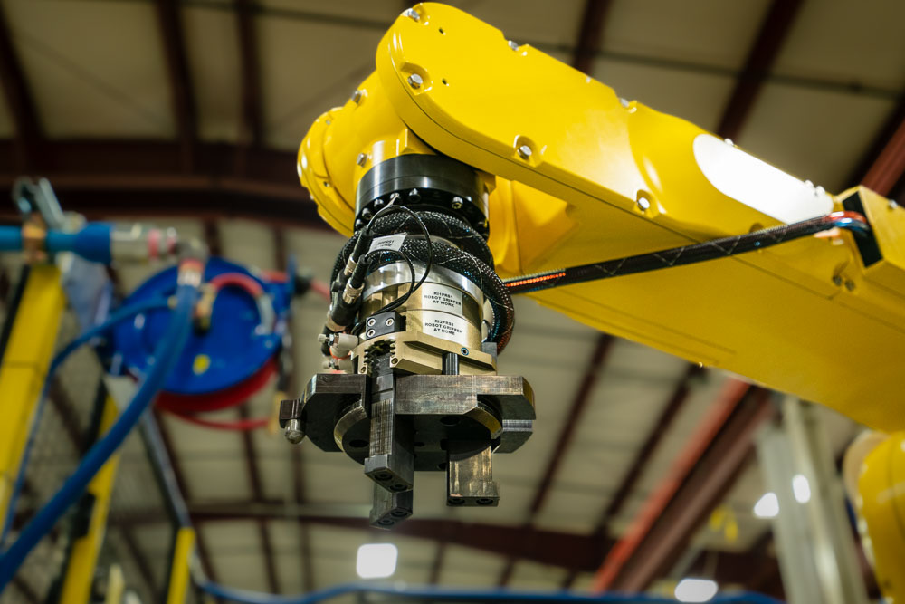 Low perspective photo of a Fanuc robotic arm used in manufacturing automation.